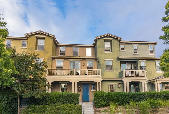 Front view of a multi-story townhouse with a balcony.