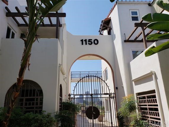 Entrance archway of a building with the number 1150 displayed above a gated entry.
