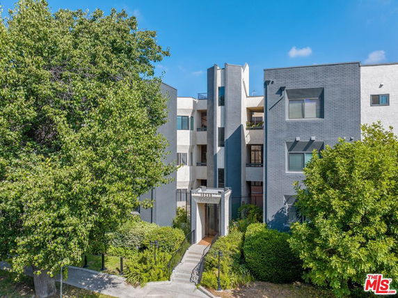 Front view of a multi-story apartment building with modern architecture.