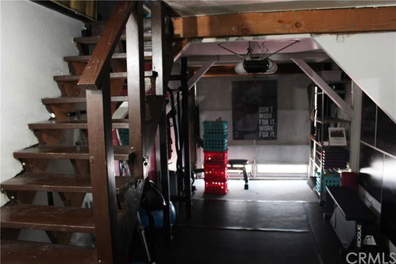Indoor gym area with exercise equipment and motivational poster.