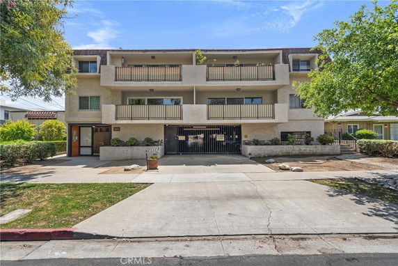 Front view of a three-story apartment building with balconies.