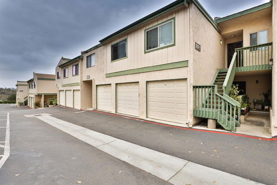 Front view of a multi-unit residential building with individual garages and external staircases.