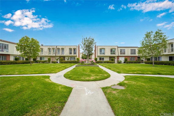 Front view of a complex with multiple two-story buildings and well-maintained lawn.