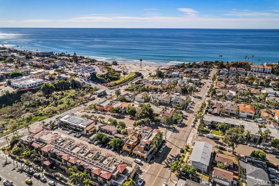 Panoramic view of a coastal area with residential buildings and roads near the beach.
