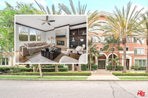 Front view of a multi-story residential building with arched windows and palm trees.