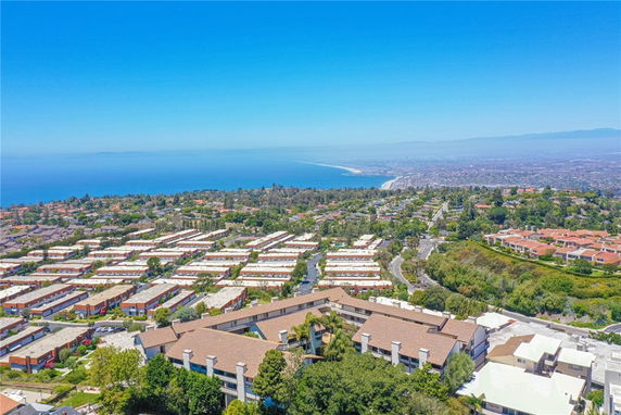 Panoramic view overlooking residential buildings and a coastline.