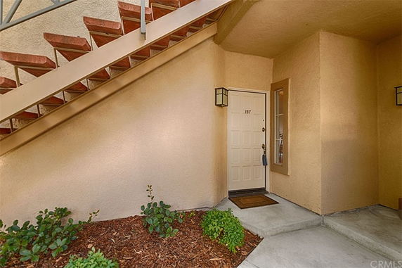 Front view of a house entrance with a staircase above.