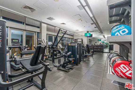 Spacious indoor gym area with various exercise equipment and weights.