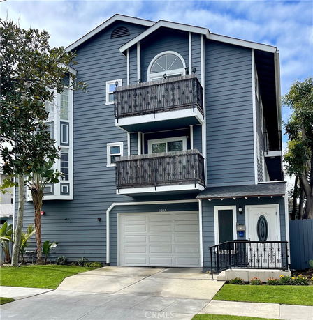 Front view of a three-story house with a double balcony and single garage.