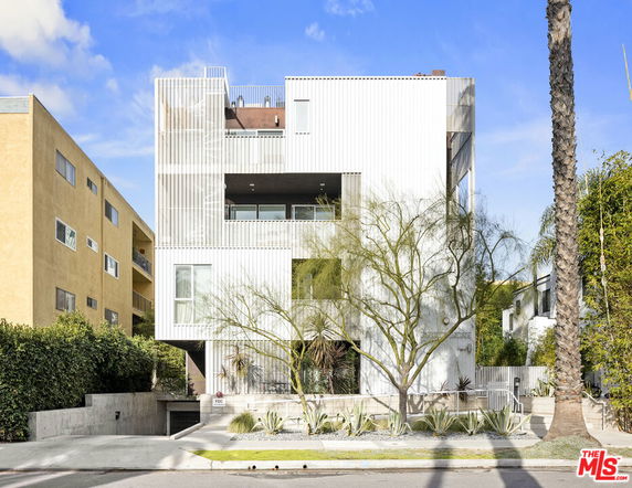 Front view of a modern multi-story building with a sleek design and large windows.