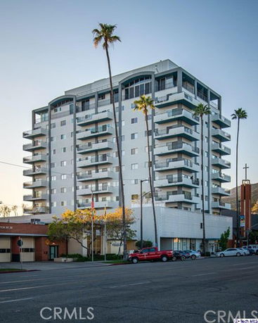 Front view of a modern multi-story apartment building with balconies.