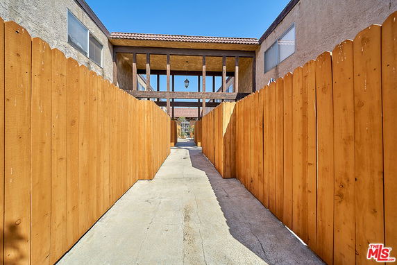 Front view of a building with a wooden fence walkway leading to the entrance.
