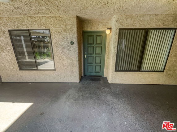 Front view of a building entrance with a green door and windows.