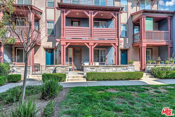 Front view of a multi-story townhouse with balconies.