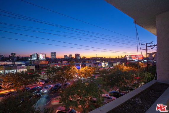 Wide angle view of city skyline and street at dusk.