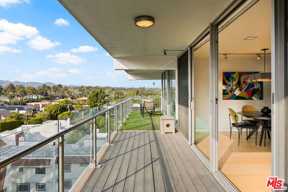 Balcony with glass railing offering a panoramic view of surrounding areas.