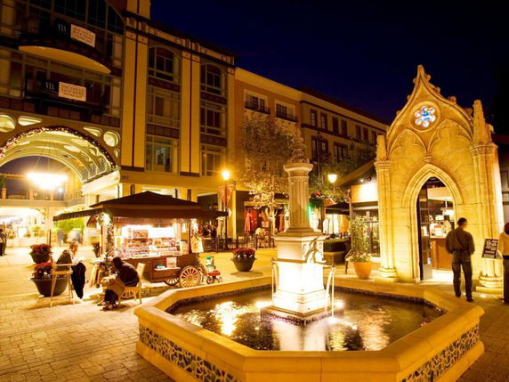 Front view of a commercial building with archways and illuminated features at night.