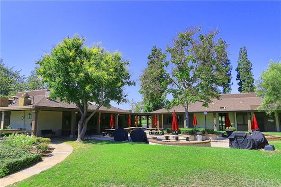 Front view of a single-story building with a courtyard and outdoor seating.