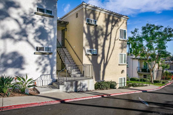 Front view of a multi-story apartment building with an exterior staircase.