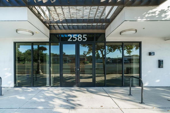 Front view of a building with a glass entrance and overhang.