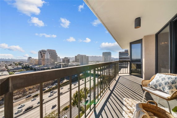 Balcony view overlooking a cityscape and highway on a clear day.