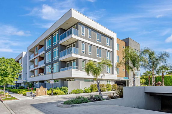 Front view of a modern multi-story residential building with balconies.
