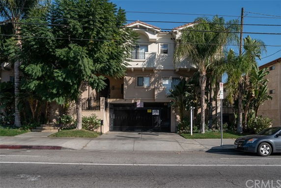 Front view of a multi-story residential building with gated entrance.