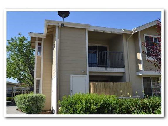 Front view of a two-story apartment building with a balcony.
