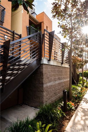 Front view of a multi-story building with metal railings and brickwork.