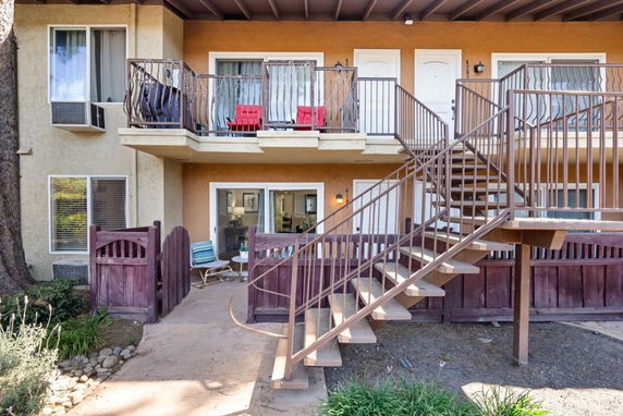 Front view of a two-story building with an exterior staircase and balconies.