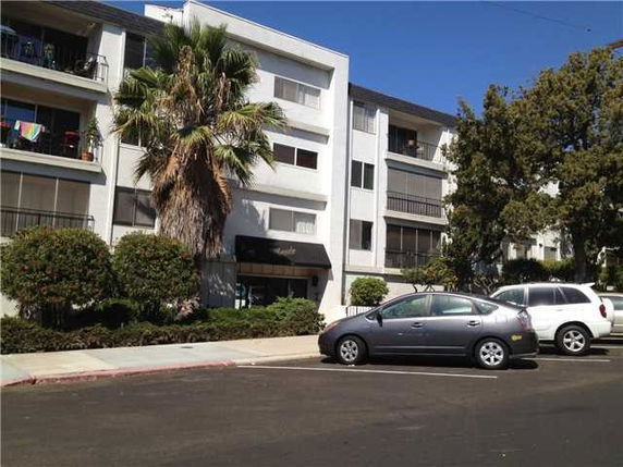 Front view of a multi-story apartment building with balconies.