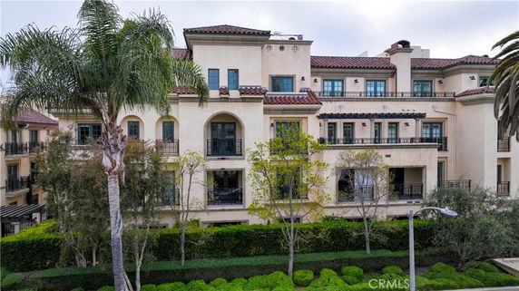 Front view of a multi-story residential building with balconies and a Mediterranean style.