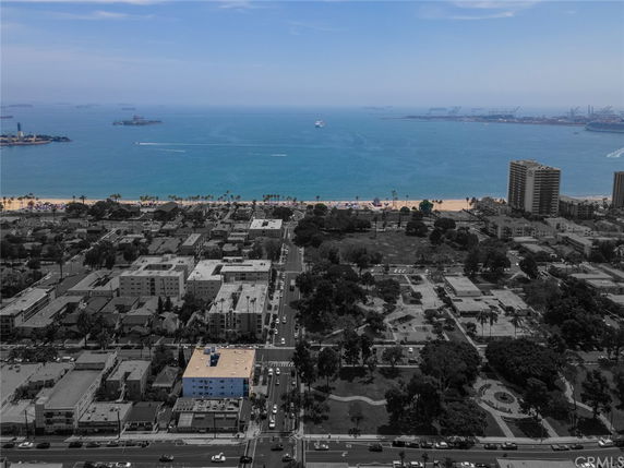 Panoramic view of a coastal cityscape with a beachfront and ocean in the background.