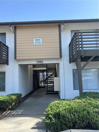 Front view of a two-story apartment building with stairs leading to the second floor.