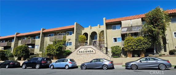 Front view of a multi-story building with a tiled roof and balconies.