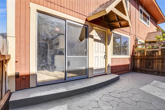 Front view of a two-story house with a sliding glass door and a main entrance door.
