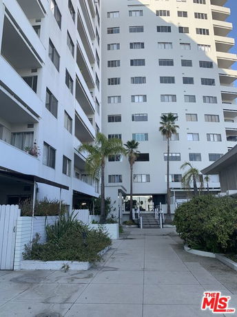 Front view of a multi-story residential building with balconies.