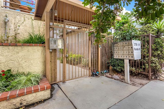 Entrance view of a residential building with a gated access.