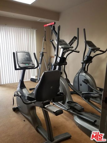 Indoor gym area with exercise machines and equipment.
