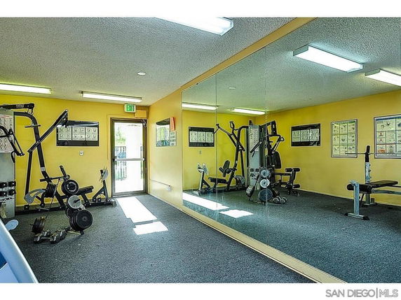 Indoor gym area with exercise equipment and mirrored walls