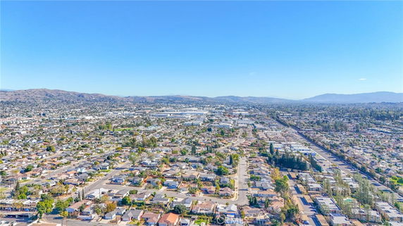 Aerial panoramic view of an urban area with residential houses and distant hills.
