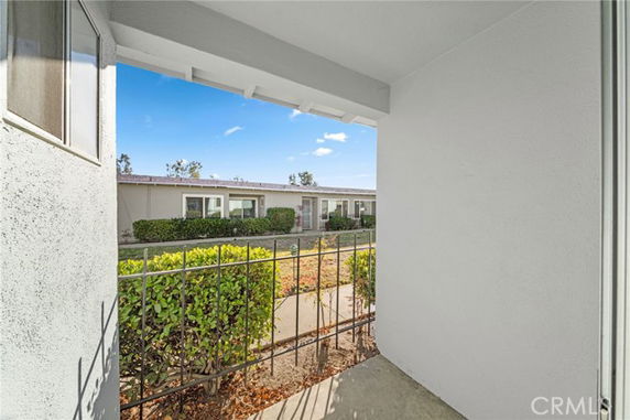 View of a one-story building from a porch area with a railing.