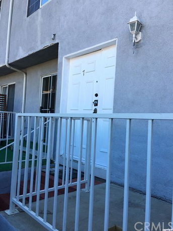 Front view of a building entrance with a white door and railing.
