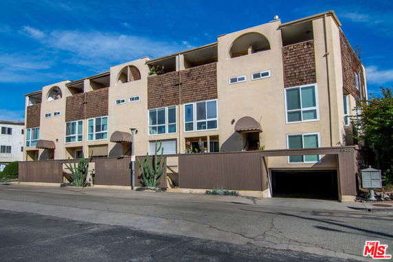 Front view of a multi-story apartment building with multiple balconies.