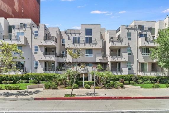 Front view of a modern multi-story apartment building with balconies.