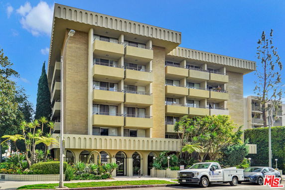 Front view of a multi-story building with balconies and a modern facade.