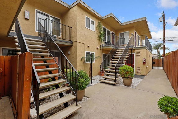 Front view of a two-story building with exterior stairs leading to upper units.