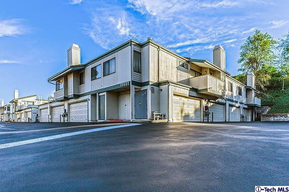 Front view of a multi-story building with garages and balconies.