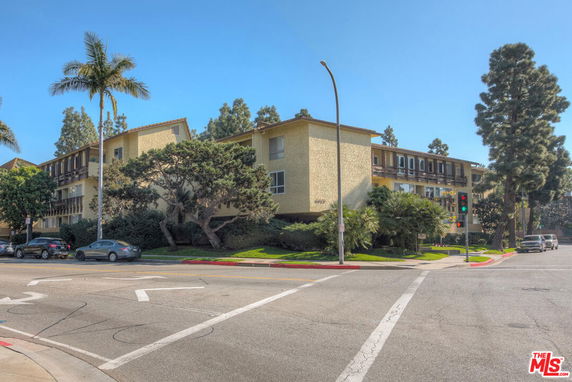 Front view of a three-story residential building at a street corner.
