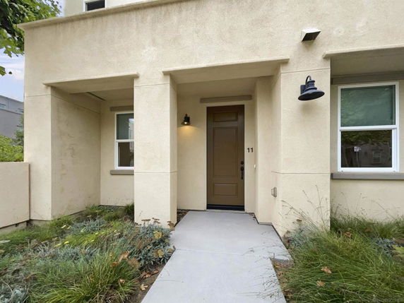 Front view of a house entrance with a covered porch and two windows.